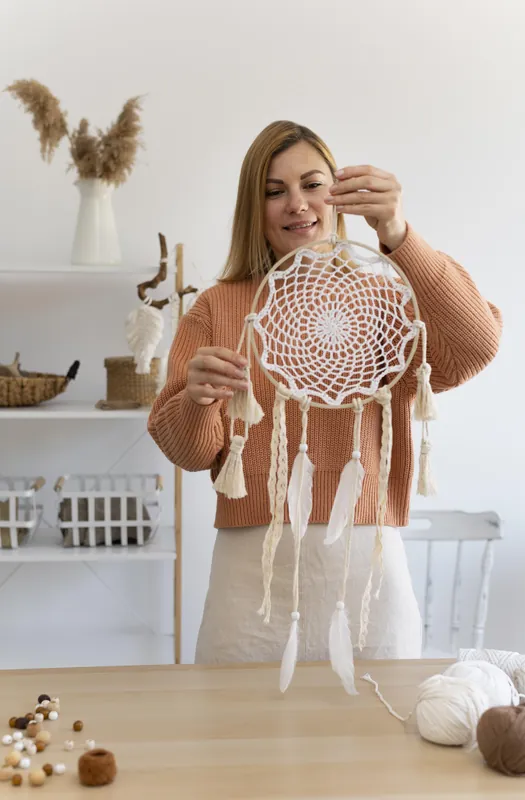 Artesã finalizando um dreamcatcher de macramê